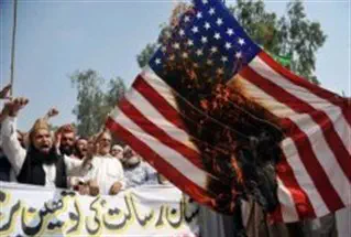 Pakistani Muslim protesters burn a US flag during a rally against an anti-Islam movie in Peshawar