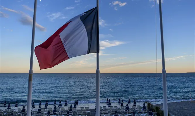 French flag flying at half mast at an empty beach on the Promenade des Anglais
