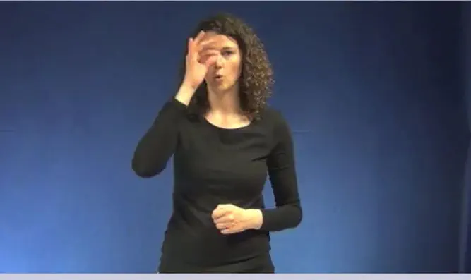A model gestures a hooked nose depicting "Jew"