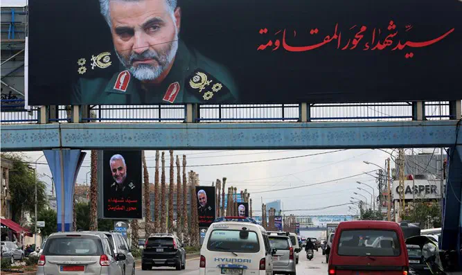 Vehicles pass picture of late Iranian Major-General Qassem Soleiman